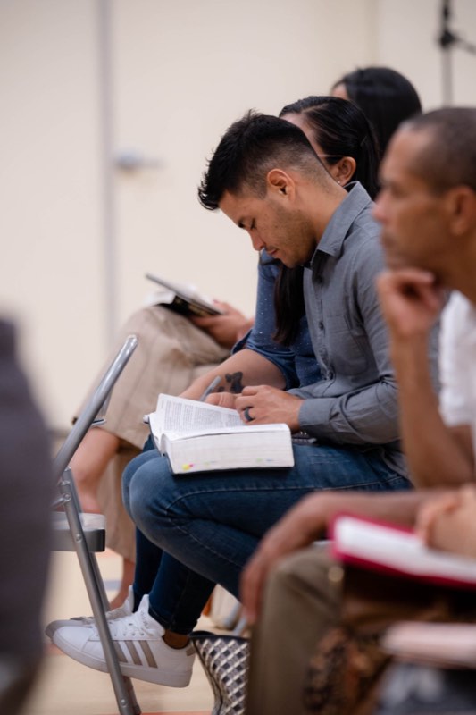 A man reading his Bible in his seat during the message