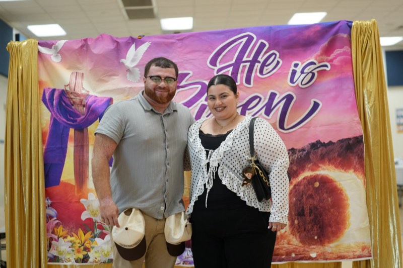 A young couple in front of the Easter photo wall
