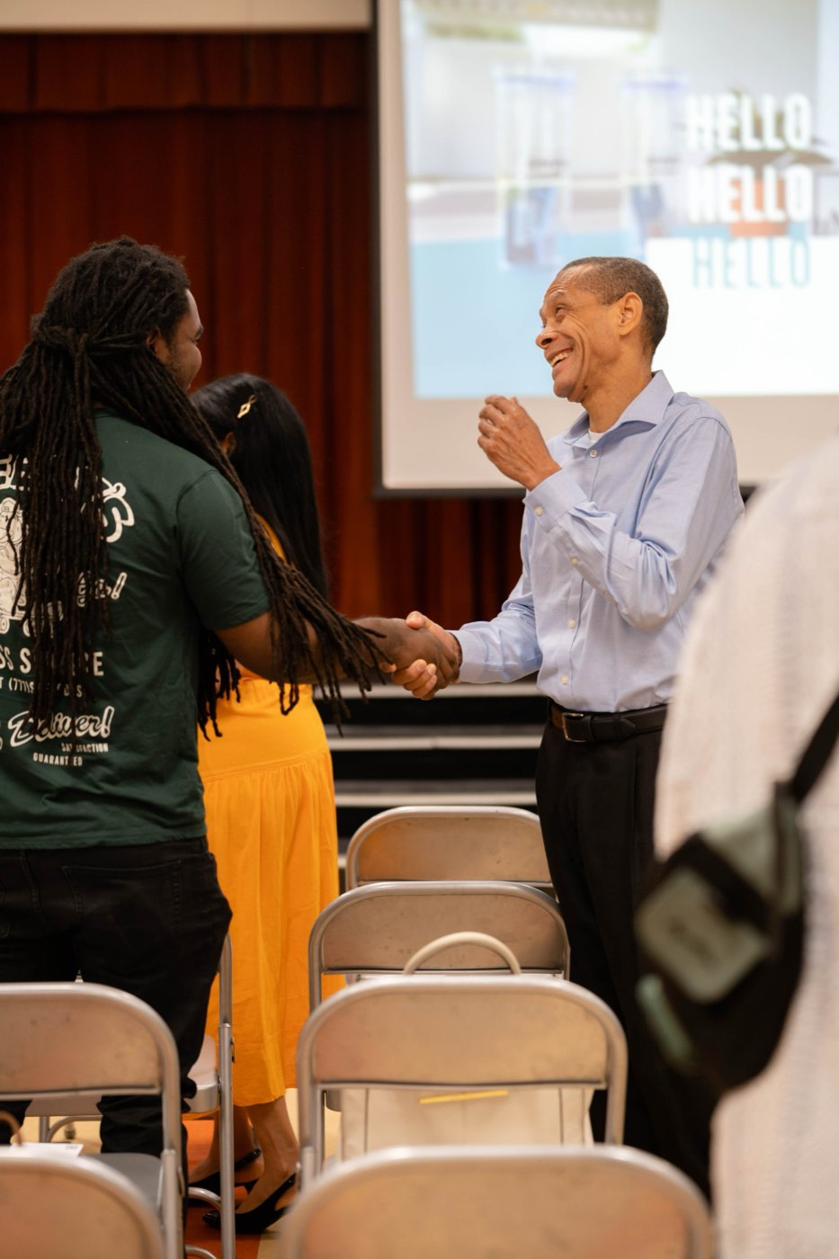 A greeter shaking hands with a first-time guest at the door on a Sunday morning