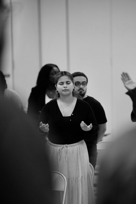 Hands raised during worship, black and white